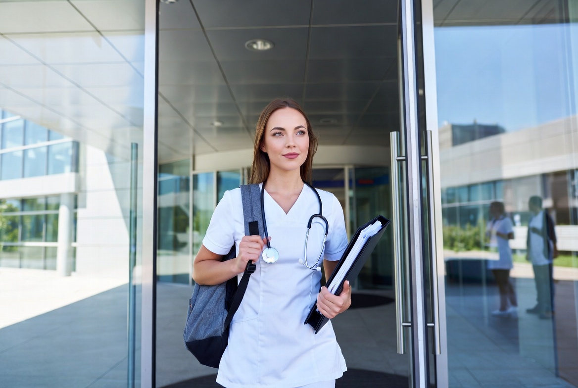 Nurse walking into a hospital ready to advance their career through an online nursing program.